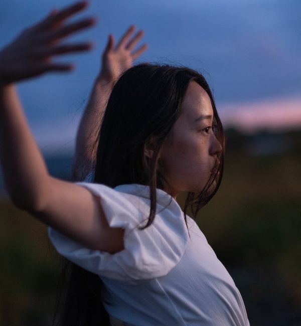 Person stretching peacefully with a serene background.